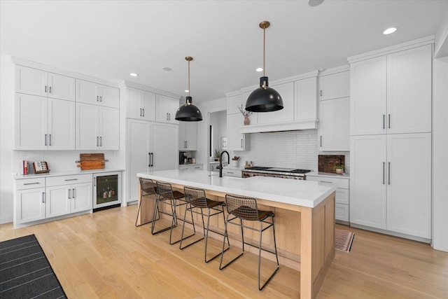2S384 Madison St, Wheaton, IL 60189 - kitchen featuring wine cooler, backsplash, light wood-style flooring, a kitchen breakfast bar, and recessed lighting