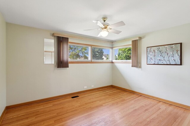 6956 Seward St, Niles, IL 60714 - empty room with light wood-type flooring, a ceiling fan, and baseboards