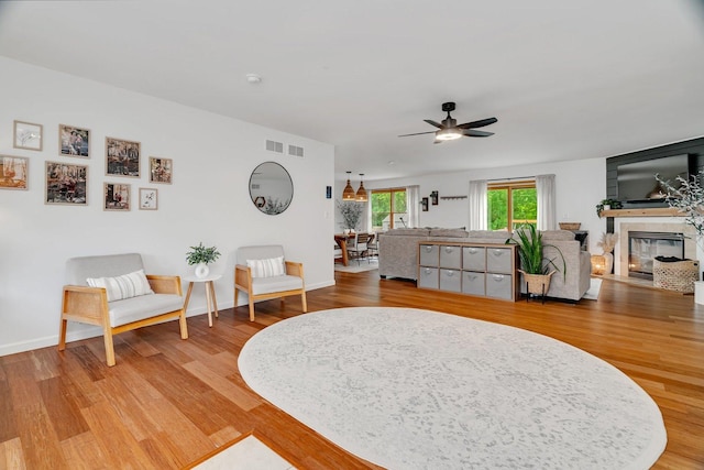 817 W 3rd St, Braidwood, IL 60408 - living room with a ceiling fan, light wood-type flooring, a fireplace, and baseboards
