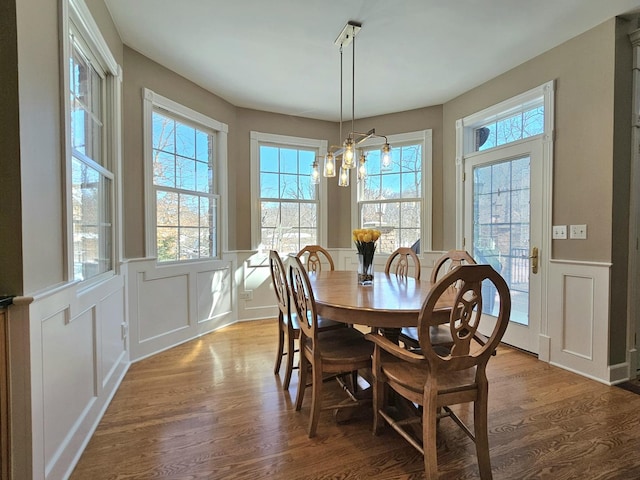 242 Hampshire Ct, New Lenox, IL 60451 - dining area featuring a decorative wall, wood finished floors, a wainscoted wall, and a chandelier