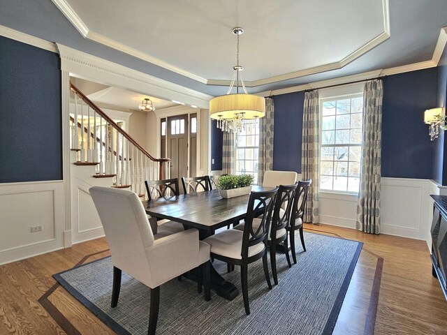242 Hampshire Ct, New Lenox, IL 60451 - dining area with a raised ceiling, a chandelier, stairs, wood finished floors, and a wainscoted wall