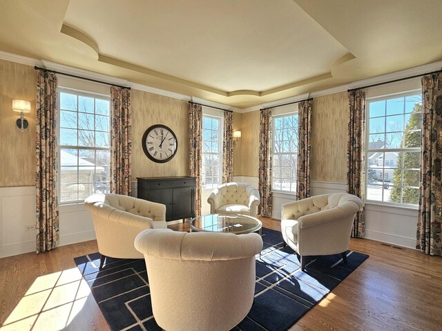 242 Hampshire Ct, New Lenox, IL 60451 - living area featuring a tray ceiling, wainscoting, wood finished floors, and a decorative wall