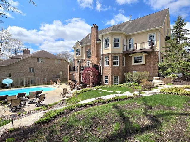 242 Hampshire Ct, New Lenox, IL 60451 - back of house featuring a balcony, a patio, a chimney, brick siding, and stucco siding