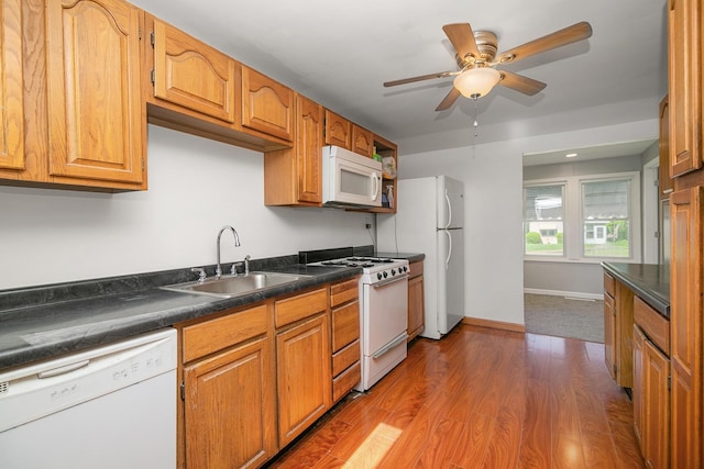 1195 W Williams St, Kankakee, IL 60901 - kitchen with white appliances, a sink, dark countertops, wood finished floors, and ceiling fan