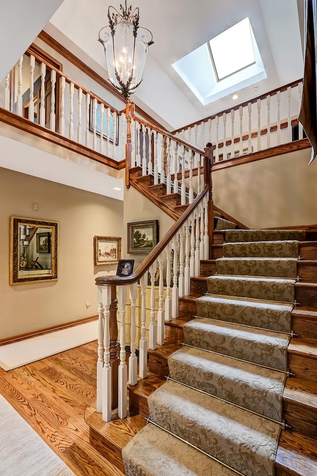 2 Hampton Ct, Burr Ridge, IL 60527 - stairway featuring a skylight, a towering ceiling, wood finished floors, and a chandelier