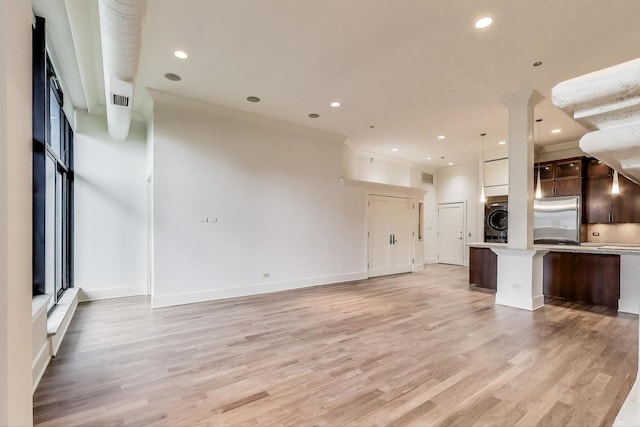 333 W Hubbard St Unit 704, Chicago, IL 60654 - unfurnished living room featuring washer / dryer, light wood-style floors, recessed lighting, baseboards, and crown molding