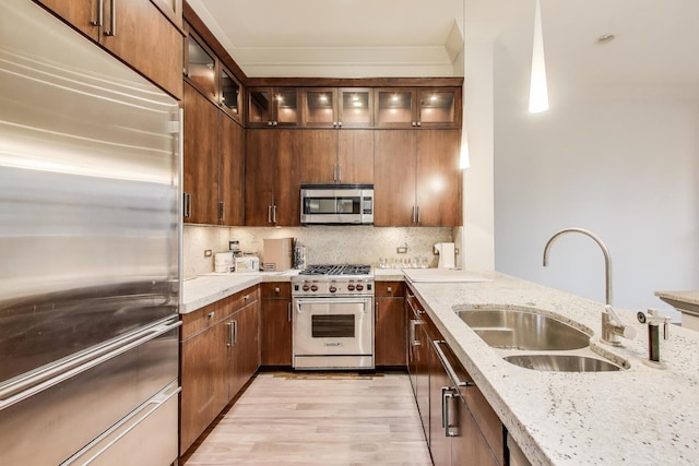 333 W Hubbard St Unit 704, Chicago, IL 60654 - kitchen with high end appliances, a sink, light wood-style flooring, light stone counters, and decorative backsplash