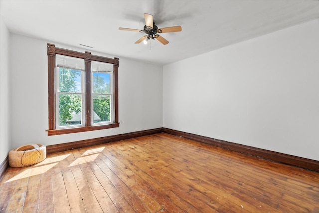 unfurnished room with baseboards, wood-type flooring, and ceiling fan