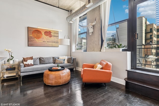living area featuring baseboards, hardwood / wood-style floors, and a view of city