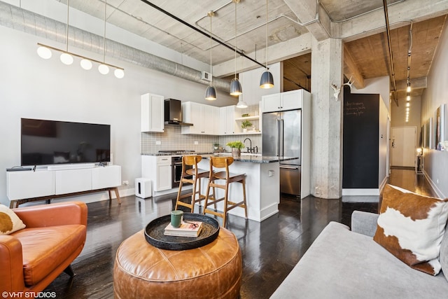living area with a high ceiling and dark wood-type flooring