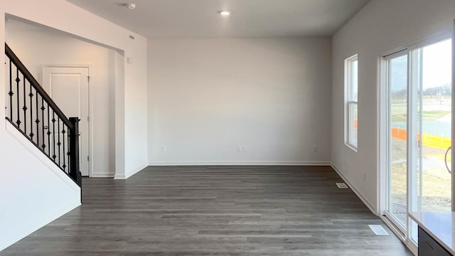 5010 Linden Rd, Mount Pleasant, WI 53403 - empty room with healthy amount of natural light, dark wood-style flooring, and stairs