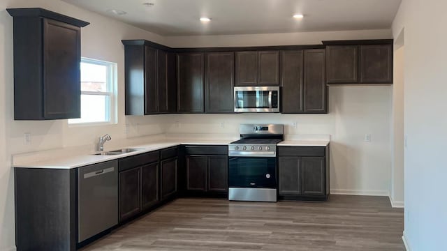 5010 Linden Rd, Mount Pleasant, WI 53403 - kitchen featuring appliances with stainless steel finishes, a sink, light wood-style floors, dark brown cabinetry, and recessed lighting