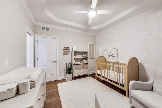 3506 N Southport Ave Unit 1N, Chicago, IL 60657 - bedroom featuring dark wood finished floors, crown molding, a crib, a tray ceiling, and a ceiling fan