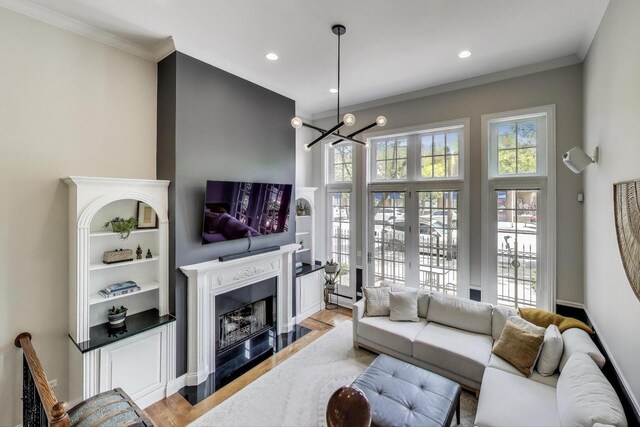 3506 N Southport Ave Unit 1N, Chicago, IL 60657 - living room featuring a fireplace with flush hearth, a chandelier, light wood-type flooring, crown molding, and recessed lighting