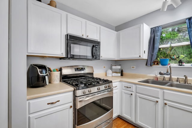 1604 Heritage Pointe Ct, Plainfield, IL 60586 - kitchen with stainless steel range with gas stovetop, black microwave, a sink, and white cabinetry