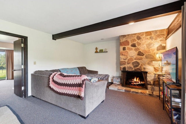 carpeted living room with a stone fireplace and beamed ceiling