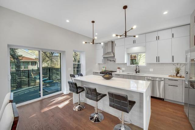 7523 Franklin St, Forest Park, IL 60130 - kitchen with dishwasher, a sink, wall chimney range hood, dark wood-type flooring, and a chandelier