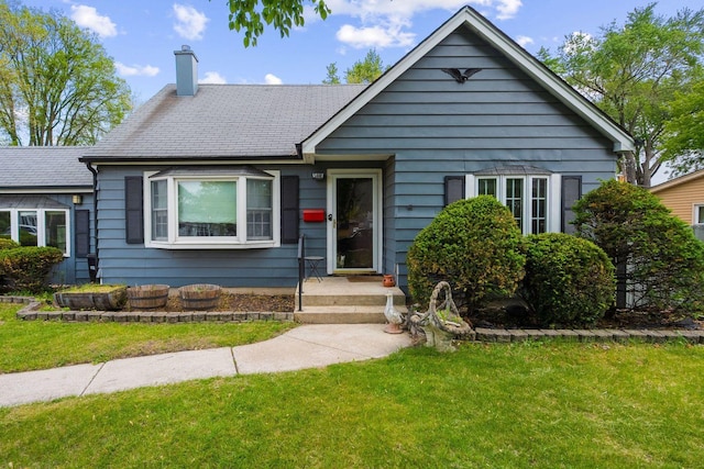 view of front of house with a chimney and a front yard