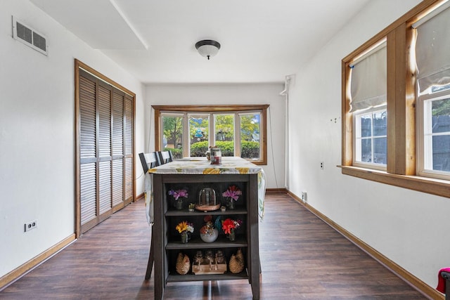 dining area with dark wood finished floors and baseboards