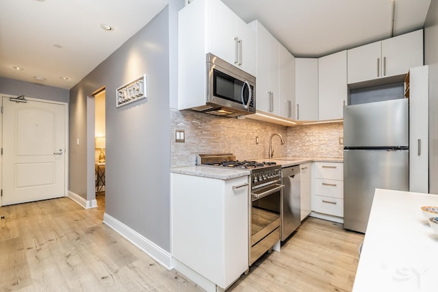 21 W Chestnut St Unit 907, Chicago, IL 60610 - kitchen featuring stainless steel appliances, light wood-style flooring, backsplash, baseboards, and recessed lighting