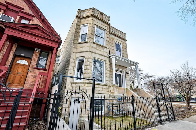 1806 S Trumbull Ave, Chicago, IL 60623 - view of front facade with stone siding, a fenced front yard, and a gate