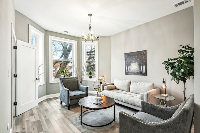 1806 S Trumbull Ave, Chicago, IL 60623 - living room with light wood-style flooring, a chandelier, and baseboards