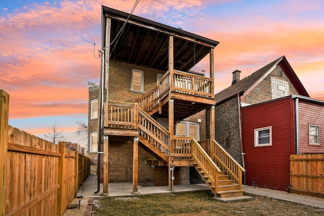 1806 S Trumbull Ave, Chicago, IL 60623 - back of property at dusk with stairway, a fenced backyard, and a patio area