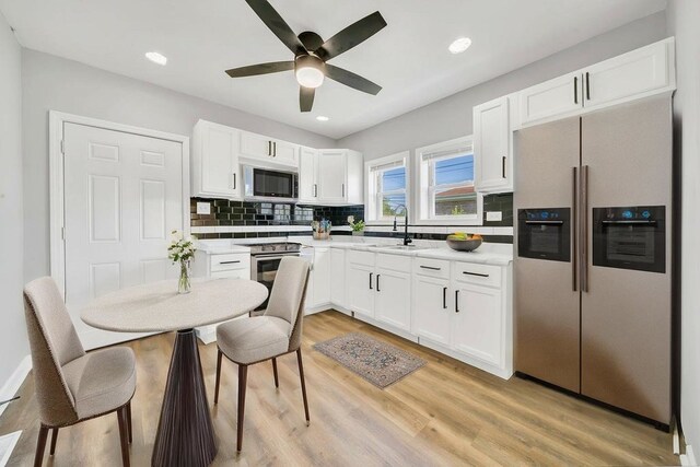 14631 Vincennes Rd, Harvey, IL 60426 - kitchen with appliances with stainless steel finishes, a sink, white cabinets, backsplash, and light wood-type flooring
