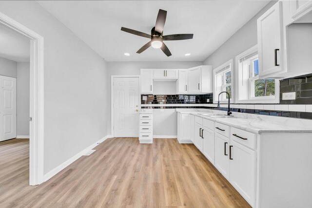 14631 Vincennes Rd, Harvey, IL 60426 - kitchen with a sink, a ceiling fan, backsplash, light wood-style floors, and white cabinetry