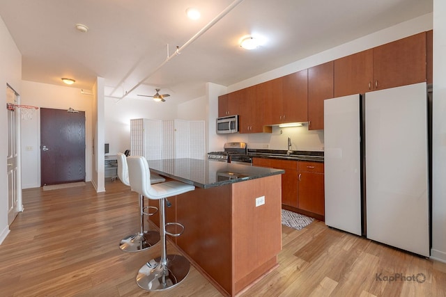 437 W Division St Unit 505, Chicago, IL 60610 - kitchen with appliances with stainless steel finishes, a sink, light wood finished floors, and a breakfast bar