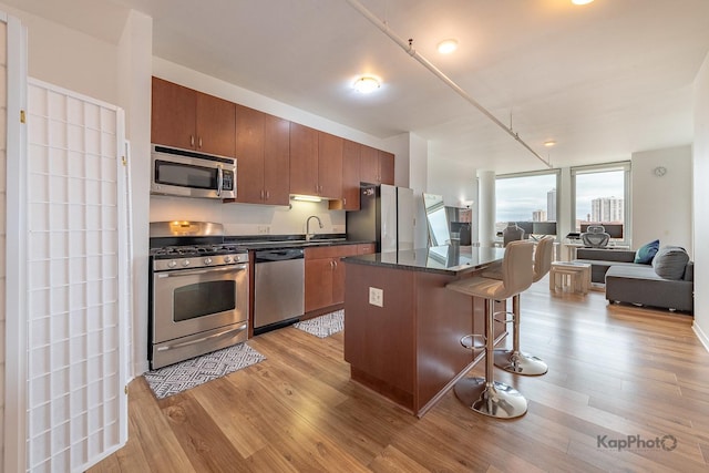 437 W Division St Unit 505, Chicago, IL 60610 - kitchen with appliances with stainless steel finishes, dark countertops, a kitchen bar, open floor plan, and a kitchen island