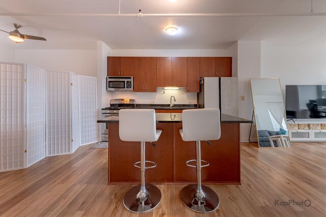 437 W Division St Unit 505, Chicago, IL 60610 - kitchen with stainless steel appliances, dark countertops, light wood-style floors, and brown cabinets