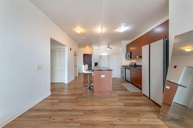 437 W Division St Unit 505, Chicago, IL 60610 - kitchen featuring appliances with stainless steel finishes, a kitchen breakfast bar, light wood-style floors, baseboards, and a center island