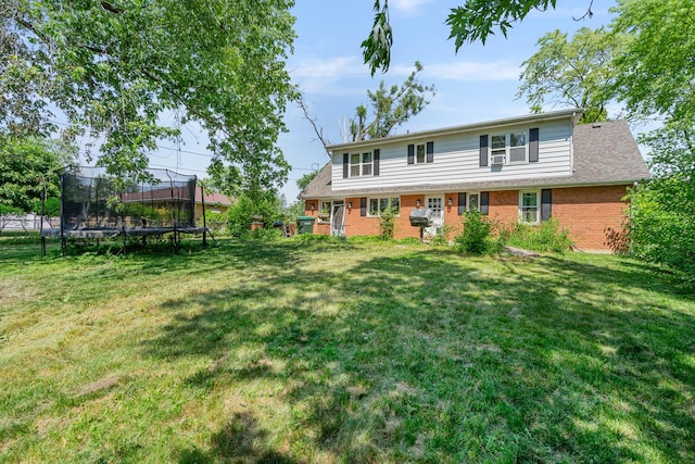 22614 S Joseph Ave, Channahon, IL 60410 - back of house featuring a trampoline, a lawn, and brick siding