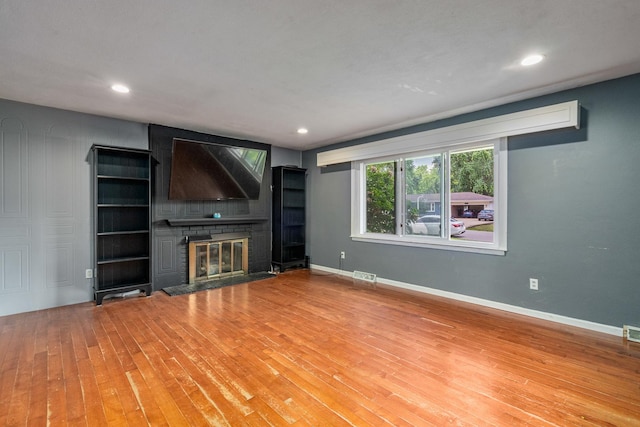 22614 S Joseph Ave, Channahon, IL 60410 - unfurnished living room featuring a glass covered fireplace, wood finished floors, and recessed lighting