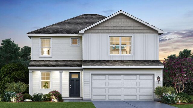 traditional home featuring driveway, a garage, and roof with shingles