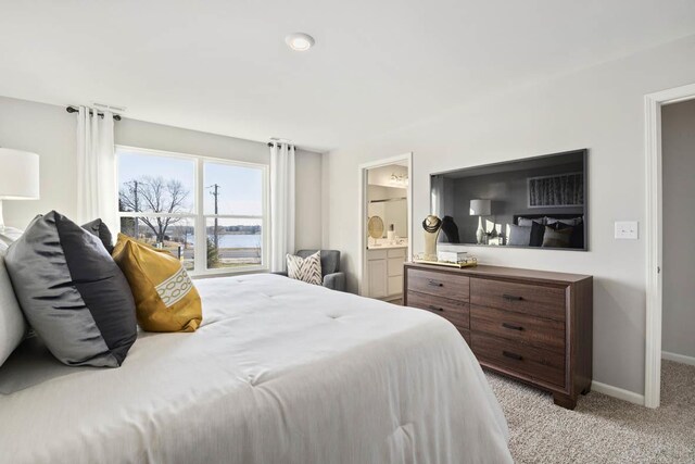 bedroom with light carpet, baseboards, and connected bathroom