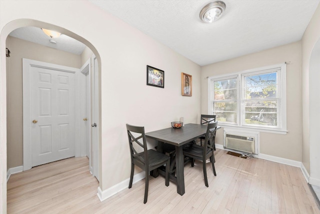 17819 Walter St, Lansing, IL 60438 - dining space featuring arched walkways, an AC wall unit, light wood-style flooring, and baseboards