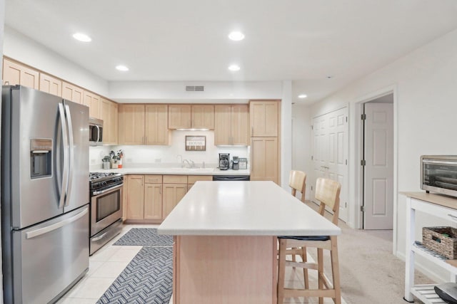 8421 Canary Grass Ln Unit 8421, Fox Lake, IL 60020 - kitchen featuring stainless steel appliances, light brown cabinets, a sink, a kitchen bar, and light countertops