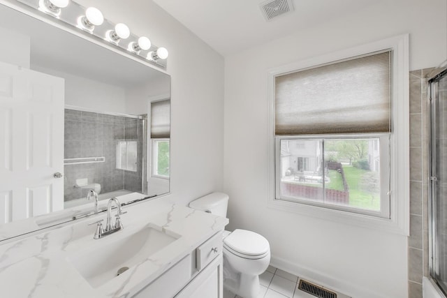 bathroom featuring a shower with shower door, plenty of natural light, toilet, and tile patterned flooring