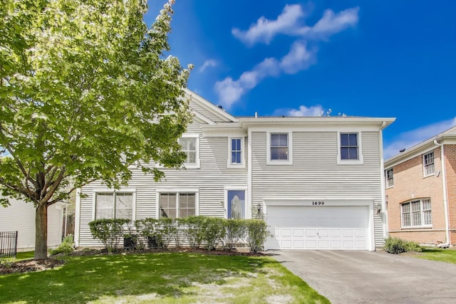 view of front of house featuring an attached garage, concrete driveway, and a front lawn