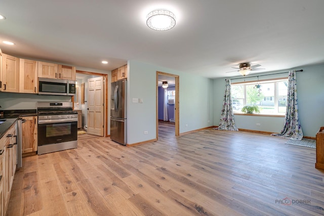 kitchen featuring stainless steel appliances, ceiling fan, dark countertops, light wood-style flooring, and baseboards