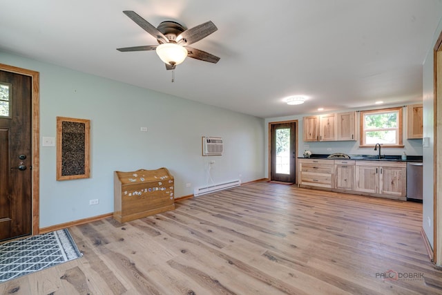 kitchen with baseboard heating, dark countertops, a sink, dishwasher, and light wood-style flooring