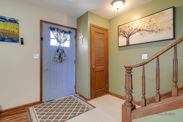 foyer entrance with baseboards and stairs