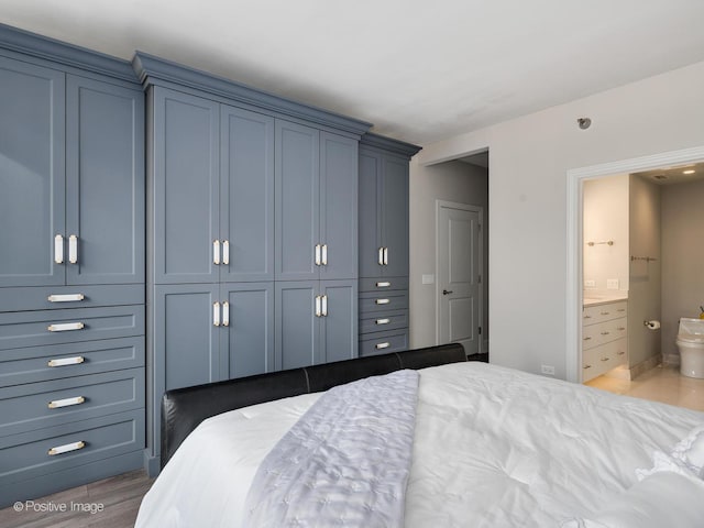720 W Randolph St Unit 907, Chicago, IL 60661 - bedroom with connected bathroom, a closet, and wood finished floors