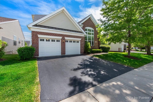 3879 Seigle Dr, Elgin, IL 60124 - traditional home with asphalt driveway, brick siding, and a front yard