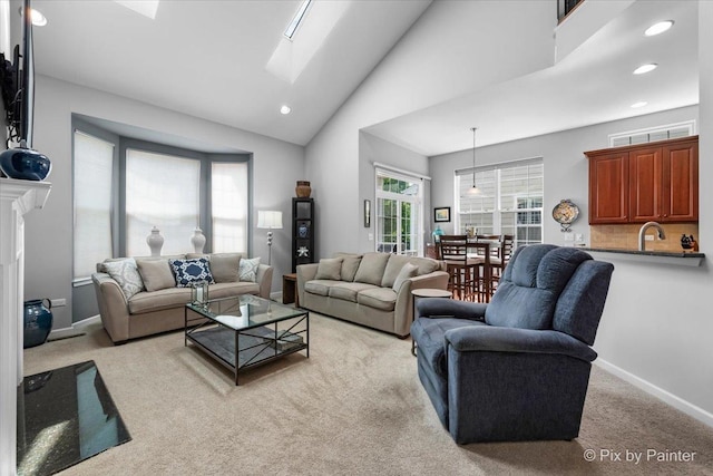 3879 Seigle Dr, Elgin, IL 60124 - living area featuring a skylight, recessed lighting, light carpet, baseboards, and high vaulted ceiling
