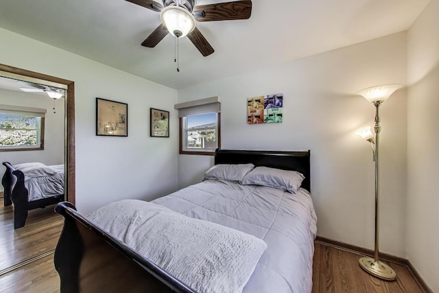 bedroom featuring wood finished floors, a ceiling fan, and baseboards