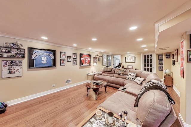 living room featuring light wood-type flooring, recessed lighting, baseboards, and crown molding