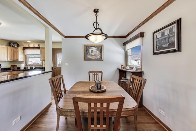 dining area featuring ornamental molding, dark wood-style flooring, and baseboards